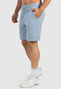 Helle blaue Shorts aus strukturiertem Stoff, mit einem elastischen Bund und Kordelzug, seitlichen Taschen und einem lockeren Schnitt.