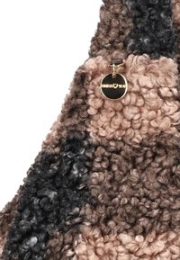 Geweven tote bag met een mix van bruin, beige en zwart, voorzien van een ronde gouden hardware-tag met de merknaam.