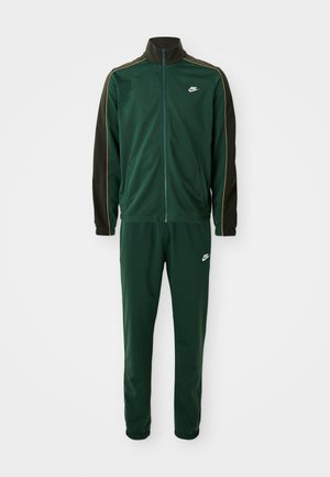 Trening verde cu jachetă cu fermoar și pantaloni. Fabricat dintr-un material neted, având mâneci verzi închise în contrast și un logo alb pe piept.