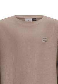 Beige textuurt sweatshirt met een ronde halslijn. Voorzien van een geweven label op de borst met de tekst "RETOUR." Gemaakt van ademend materiaal.