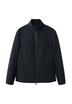 Sort lynlåstrøje med høj krave, to brystlommer med klap og to sidelommer med lynlås, lange ærmer og lige kant.