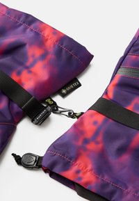 Vijolična in rdeča vzorčasta jakna Gore-Tex z črnimi trakovi, plastičnimi sponkami in blagovnimi oznakami. Ima gladko površino in vodoodpornem dizajnu.