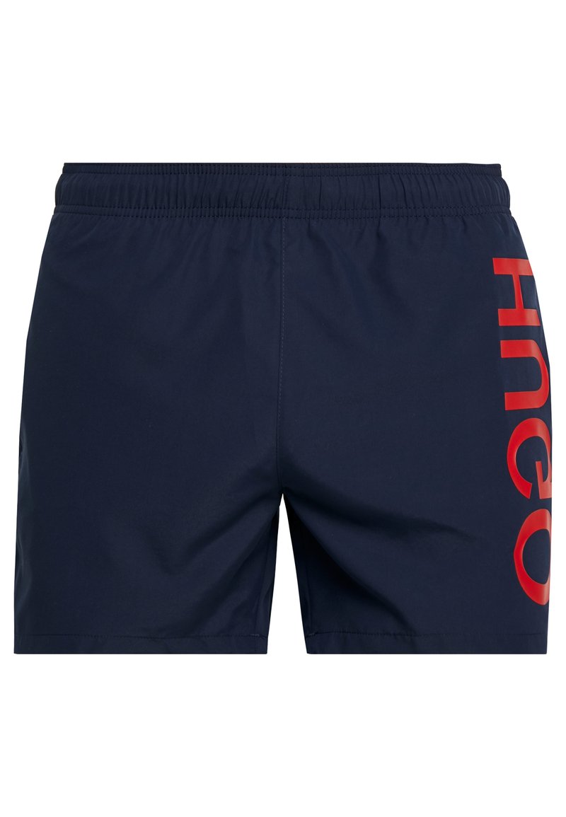 Marineblaue Badehosen mit einem elastischen Bund und auffälligen roten "HNEO"-Buchstaben auf der linken Seite. Glatter, leichter Stoff, knielang.