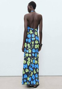 Floral maxi dress with a halter neckline, featuring a black base, blue and green flower patterns, and an open back design.