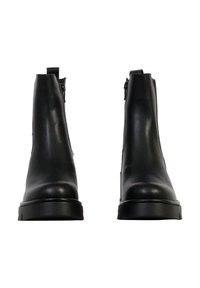 Bottes basses en cuir noir à finition lisse, avec fermetures éclair latérales et semelle épaisse, conçues pour une silhouette épurée.