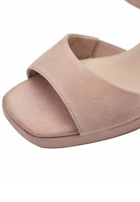 Sandal de ante en color rosa empolvado con una amplia correa frontal, una plantilla acolchada y una forma de puntera redondeada. Suela plana con un detalle de tracción mínimo.