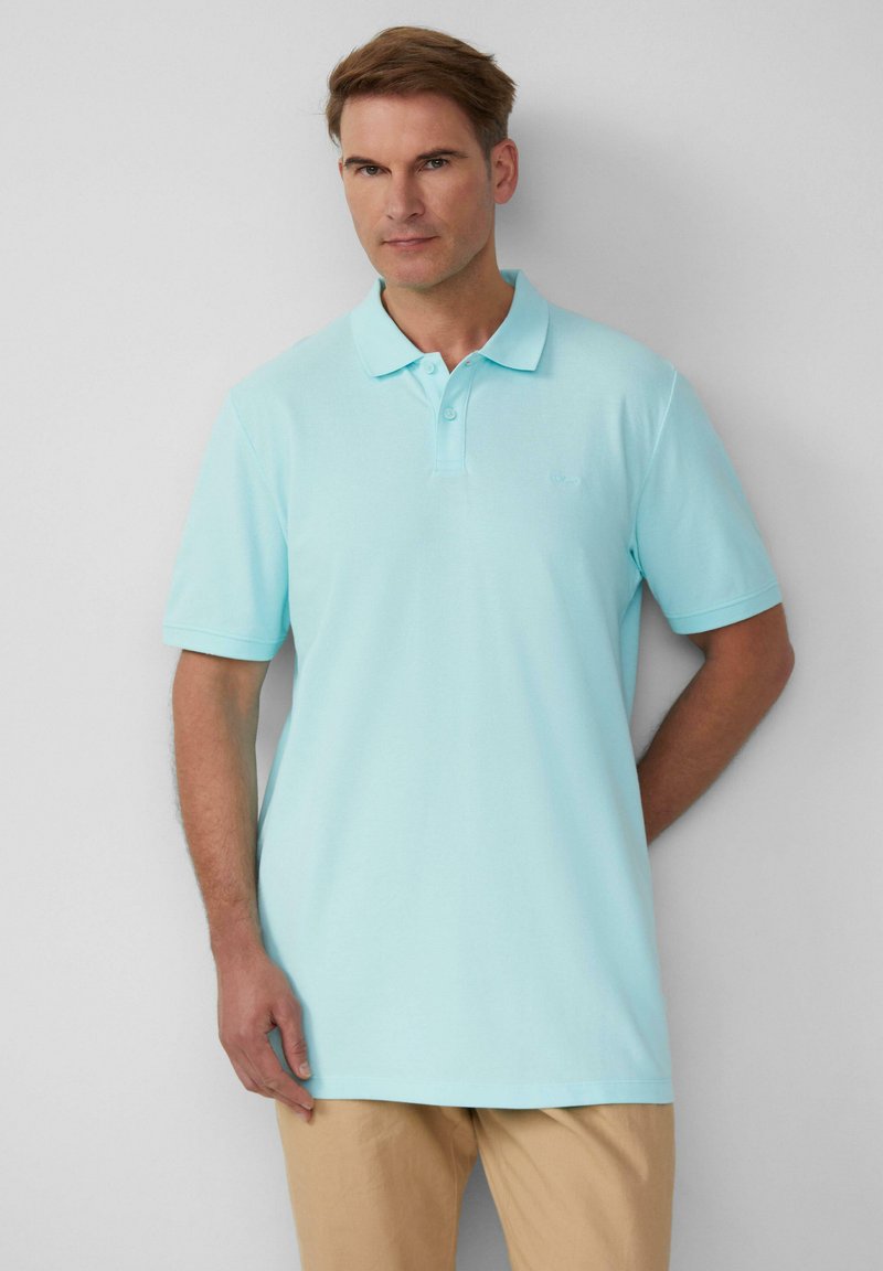 Lichtblauwe polo van katoen, met een klassieke kraag, korte mouwen en een subtiel logo op de borst. Glad oppervlak.