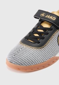 Αθλητικό παπούτσι σε ασπρόμαυρο μοτίβο με ελαστική  σόλα, διακοσμημένο με χρυσές λεπτομέρειες, με λουράκι βέλκρο και μαύρα κορδόνια. Υπέροχο υφασμάτινο επάνω μέρος με υφή.