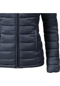 Veste matelassée bleu marine en tissu léger, avec des sections matelassées horizontales, une fermeture éclair à l'avant, et une poche latérale zippée.