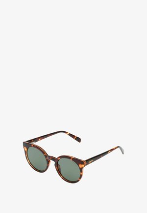 Lunettes de soleil rondes avec une monture en écaille de tortue et des verres verts. Les branches présentent un subtil accent doré avec des détails de marque.