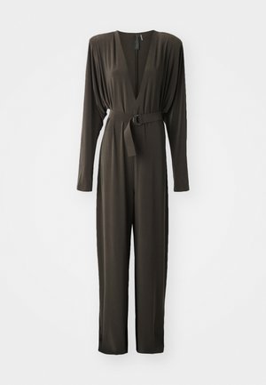 Combinaison à manches longues de couleur olive avec un profond décolleté en V, taille ceinturée avec une boucle circulaire et pantalon fuselé. Matière lisse et extensible.