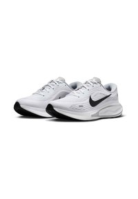 Scarpe da corsa leggere e bianche con tomaia in rete traspirante, baffo Nike nero, linguetta imbottita e suola intermedia bianca spessa con suola nera testurizzata.
