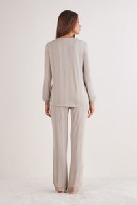 Lichtgrijze pyjama-set met een lange mouwtop en wijde broek met verticale gewatteerde strepen. Zacht materiaal, relaxte pasvorm en geen zichtbare hardware.