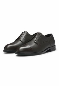 Scarpe eleganti in pelle marrone con finitura a textura, con punta liscia, sei occhielli per i lacci e suola in gomma piatta. Brandizzazione discreta sul tallone.