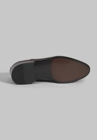 Semelle de chaussure habillée marron avec une finition lisse, une forme courbée et un talon en caoutchouc noir. Présente un logo subtilement embossé au dos.