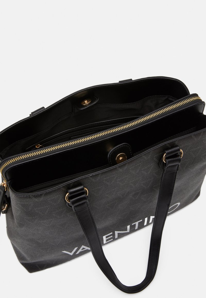 Bolso tote de cuero negro con un exterior texturizado, herrajes dorados, cierre de cremallera y un compartimento interior; presenta el logo "Valentino".