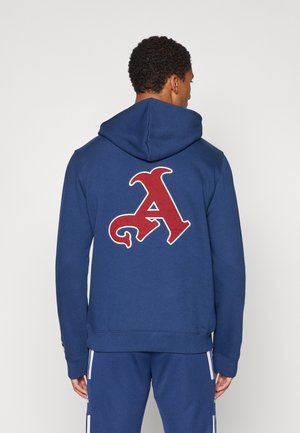 Navy blue hooded sweatshirt featuring a large red "A" logo on the back, made from a soft, textured fabric with a relaxed fit.