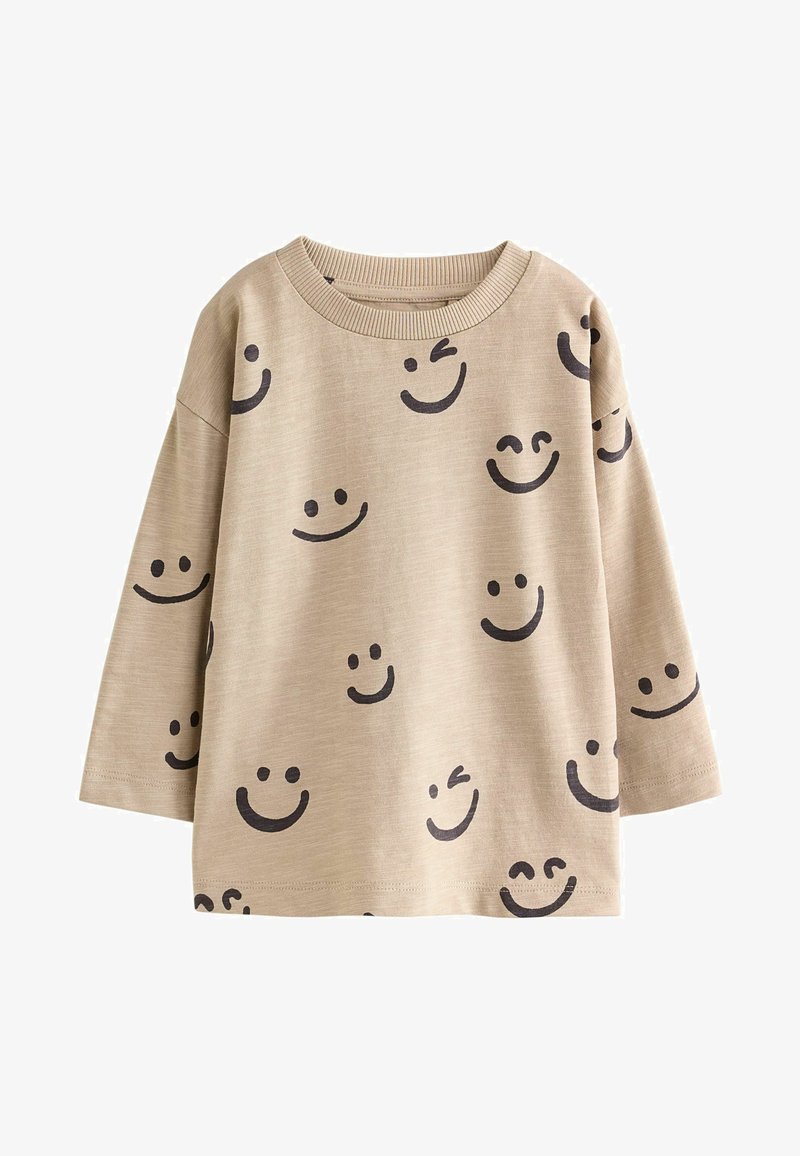 Camicia beige a maniche lunghe con molte faccine nere sorridenti, comprese espressioni che strizzano l'occhio e con gli occhi chiusi, stampate su tutto il tessuto.