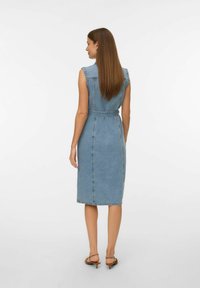 Denim kleita ar bezpiedurkņu dizainu, gaiši zila krāsa, pieguļoša josta un ceļgala garums. Iespējas šuvju detaļas un jostas ar sprādzi.