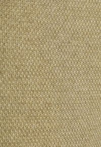 Strickstoff in hellbeige mit feiner Textur; gleichmäßig gewebt mit einem weichen Aussehen, geeignet für Bekleidungs- oder Polsteranwendungen.