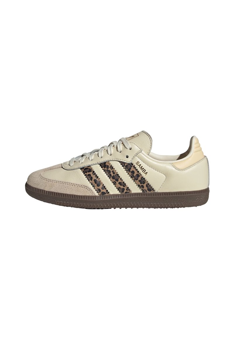 Sneakers w kolorze brązowym i kremowym, wykonane z zamszu i skóry, z trzema brązowymi paskami w kwiatowy wzór oraz teksturowaną brązową podeszwą.