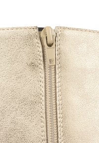 Custodia con zip di colore oro metallizzato, con una superficie texture, dotata di una zip in plastica e cuciture visibili lungo i bordi.