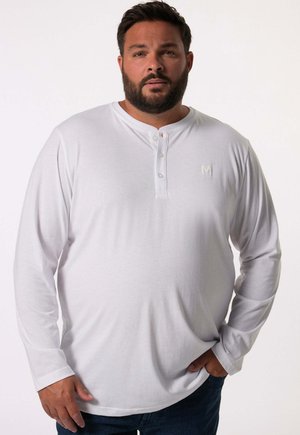 Biała longsleeve koszula henley z trzema guzikami przy dekolcie i subtelnym logo "M" na piersi, wykonana z miękkiej, gładkiej tkaniny.