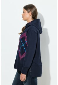 Felpa con cappuccio blu navy con un design grafico geometrico rosa e blu. Realizzata in morbido tessuto, presenta una vestibilità rilassata e polsini a coste.