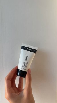 Tubo bianco con un tappo nero, etichettato "Siero di Vitamina C." Il design è elegante, con testo ridotto al minimo e linee pulite. Contiene 30 ml.