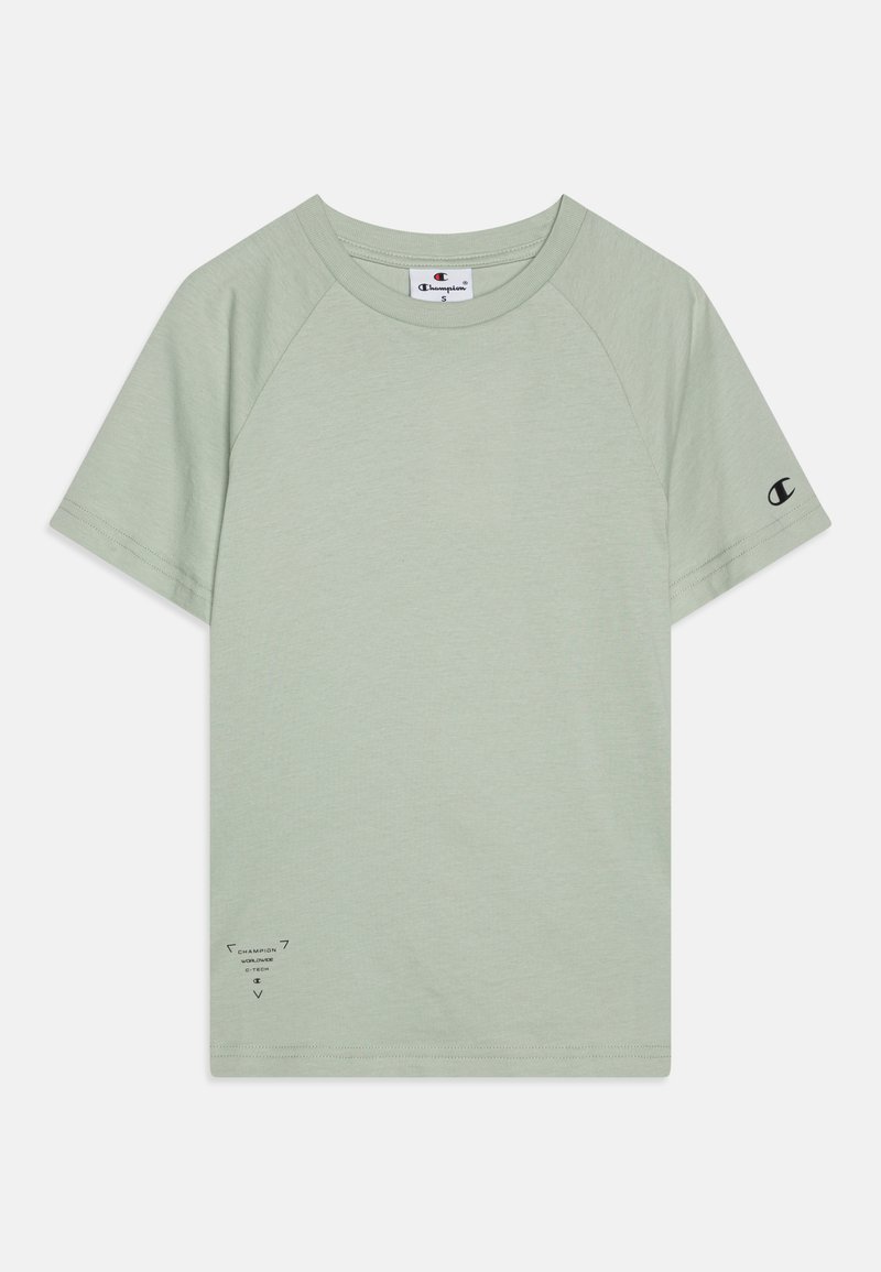 Világoszöld pamut póló rövid raglán ujjakkal, kerek nyakkal, és fekete logóval a bal ujján és az elülső alsó sarkán.