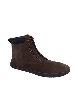 Dunkelbrauner Veloursleder-Hochschaftschuh mit schwarzer Sohle, Metallösen und schwarzem gepolstertem Kragen rund um den Knöchel, von der Seite gezeigt.