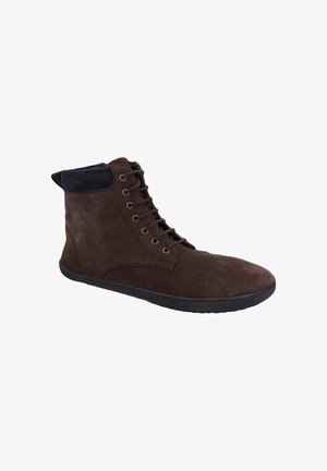 Dunkelbrauner Veloursleder-Hochschaftschuh mit schwarzer Sohle, Metallösen und schwarzem gepolstertem Kragen rund um den Knöchel, von der Seite gezeigt.