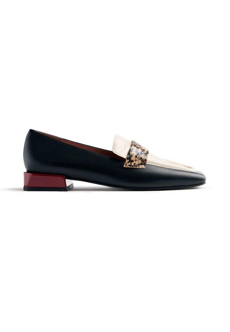 Mocassin en cuir noir avec un accent crème et à motifs imprimés, doté d'un talon rouge triangulaire et d'un design lisse et élégant.