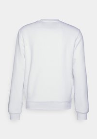 Yksinkertainen valkoinen crewneck-huppari, joka näkyy takaa, pitkähihaisilla ja ribbireunuksilla varustetulla helmalla.