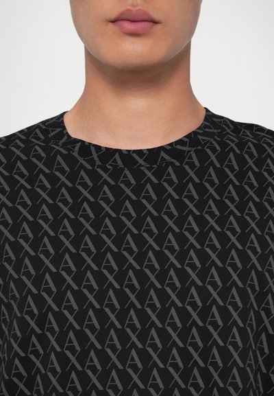 T-shirt en coton noir avec un motif de logo gris foncé répété, design à col ras du cou et texture douce.