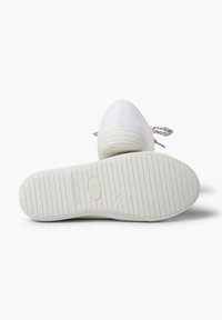 Sneaker bianche in tela con suola in gomma testurizzata e lacci a disegno. Punta arrotondata e design minimalista. Suola piatta e flessibile.