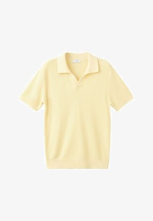 Polo a maniche corte in maglia giallo pallido con motivo strutturato e colletto morbido, distesa su uno sfondo bianco.