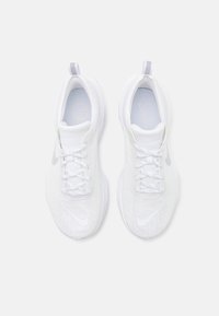 Baskets de course blanches avec un dessus texturé, bout rond et lacets. Présente un logo swoosh argenté et une languette au talon.