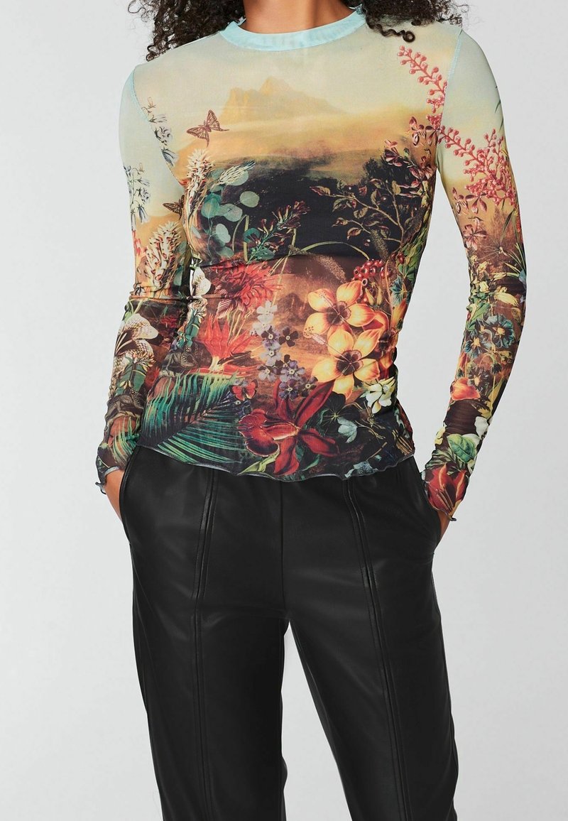 Langærmet top med et tropisk blomstermønster i levende farver, med en lyseblå halsudskæring og en tætsiddende silhuet.
