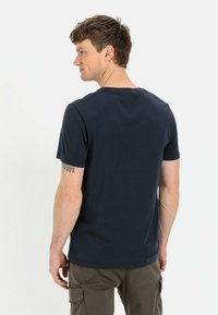 Marineblauwe korte mouwen t-shirt van katoen, met een ronde hals en een soepele textuur. Inclusief een klein accentlogo nabij de zoom.