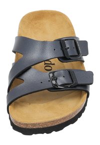 Sandale à glissière en cuir noir avec deux brides réglables, semelle en liège et semelle texturée. Doublure intérieure en suède beige doux.
