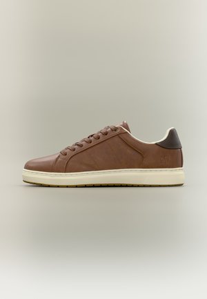 Sneaker in pelle marrone a taglio basso con suola in gomma crema e pezzo posteriore marrone scuro, design con lacci laterali, su sfondo neutro.