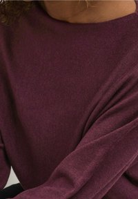 Burgunderfärgad stickad tröja med en mjuk textur, bred båtnek, långa ärmar, av avslappnad passform och ribbade detaljer.