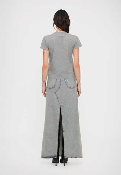 Grå kortermet T-skjorte kombinert med lang, grå denimskjørt med høyt splitt og kontrastfarget søm på buede lommer.