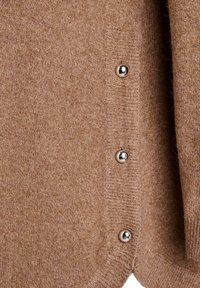 Brūns adīts kardigāns ar apaļu apakšu, piecām metāla pogām un mīkstu tekstūru. Nav redzami nekādi zīmējumi vai papildu akcenti.