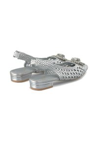 Scarpe intrecciate argento con punta appuntita, tacco basso a blocco e decorazioni sulla tomaia. Presentano una superficie testurizzata e un design aperto.