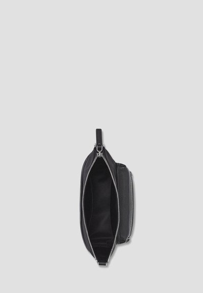 Czarna skórzana torba z zamkiem błyskawicznym. Charakteryzuje się gładką fakturą i pojedynczą rączką. Wnętrze wyłożone jest tkaniną, oferując przestronną komorę.