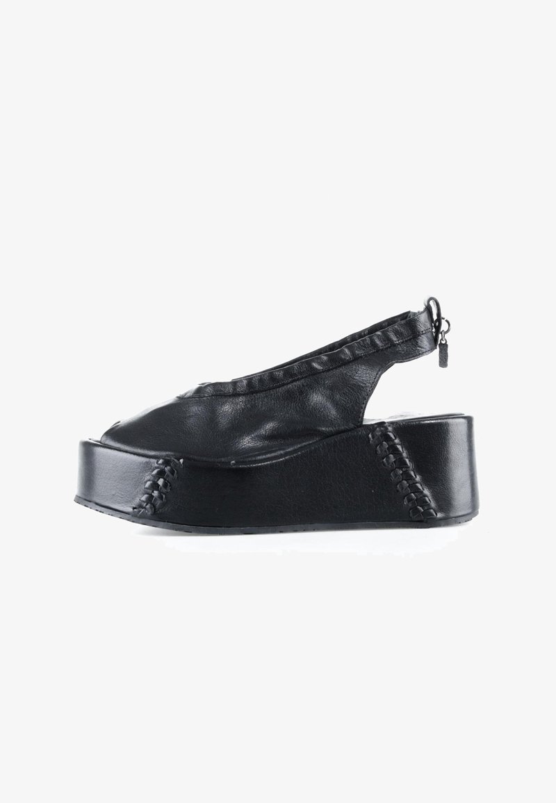 Sandale plateforme en cuir noir avec bout ouvert, bride arrière, détails de couture et tirette sur une semelle épaisse.