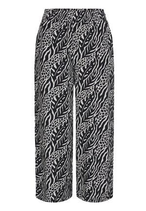 Pantalones de pierna ancha en blanco y negro con un audaz estampado animal abstracto que combina hojas y rayas de cebra.