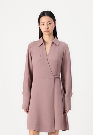 Abito a maniche lunghe avvolgente in rosa polveroso, realizzato in tessuto testurizzato. Presenta un colletto, una cintura laterale e una tasca applicata sul lato sinistro del petto.